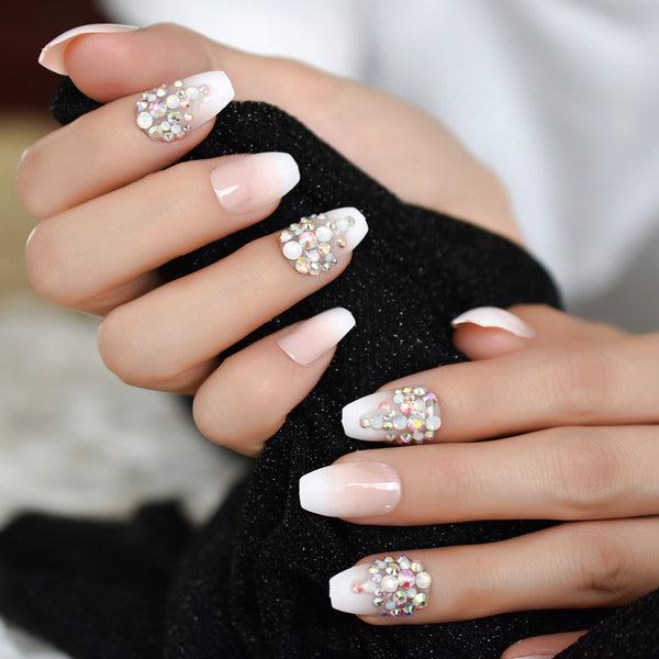 Hand model wearing French tip nails with rhinestones 