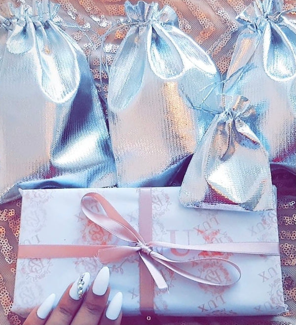 Premium Gift wrap with SB Lux Tissue Paper, a bow tied in pink ribbon and silver bags. 