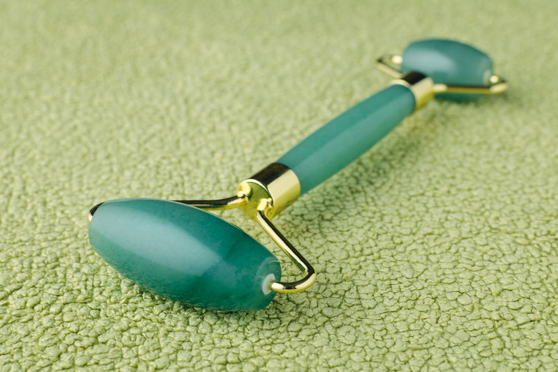 Double sided green adventuring jade roller on green background 