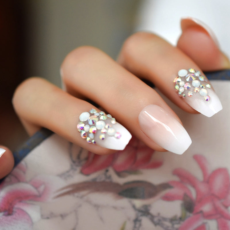 Hand model wearing french ombre nails with rhinestones 