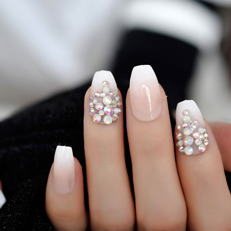 Hand  model wearing french ombre nails with rhinestones 